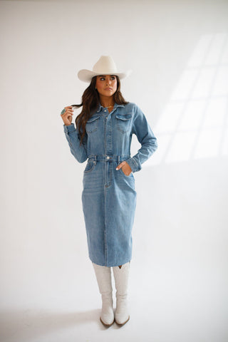 model wearing lulu denim dress by dear john in a medium wash with white boots and cowboy hat